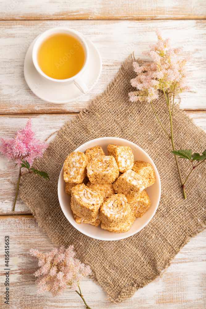 Traditional turkish delight (rahat lokum) with cup of green tea on a white wooden background. top view, close up. Traditional turkish delight (rahat lokum) with cup of green tea on a white wooden background. top view, close up.