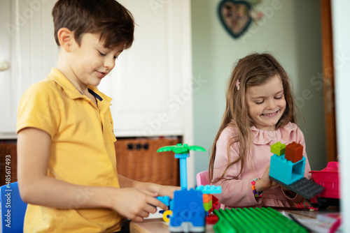 SIster and brother playing with toys at home. Little childs playing with lots of toys indoor..