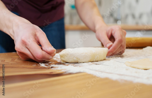 Girl preparing vegetarian pies with filling at home in the kitchen close-up. soft focus