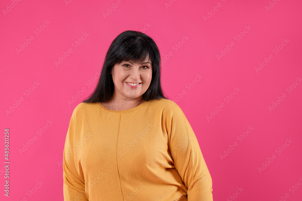Beautiful overweight mature woman with charming smile on pink background Beautiful overweight mature woman with charming smile on pink background