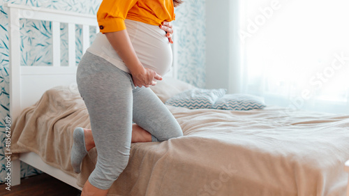 Photos Pregnant woman has stomachache in bedroom