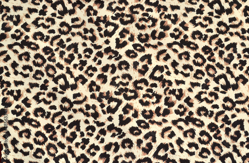 Leopard print on thin, mass-produced silk fabric. Abstract animal skin pattern, background