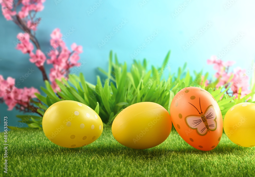 Easter eggs on green grass on blue background.