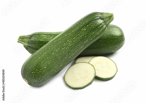 Whole and cut ripe zucchinis on white background