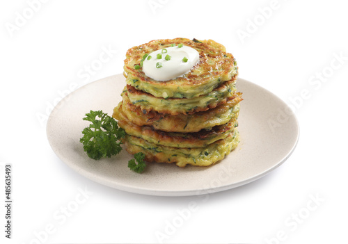Delicious zucchini fritters with sour cream isolated on white
