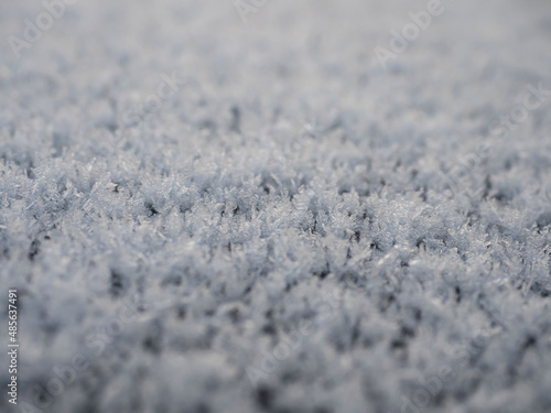 Snowflakes, snow crystals on the car roof. Freeze, frost, macro