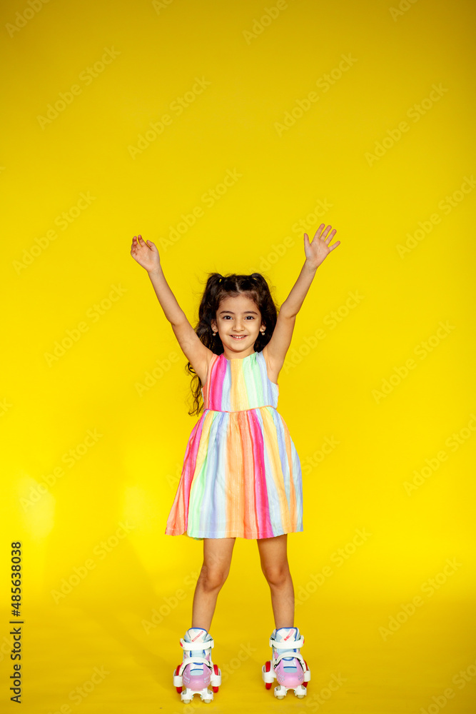 Funny little girl about 6 years old in casual summer clothes posing on a plain yellow background. The concept of a child's lifestyle. Layout of the copy space. Funny little girl about 6 years old in casual summer clothes posing on a plain yellow background. The concept of a child's lifestyle. Layout of the copy space.