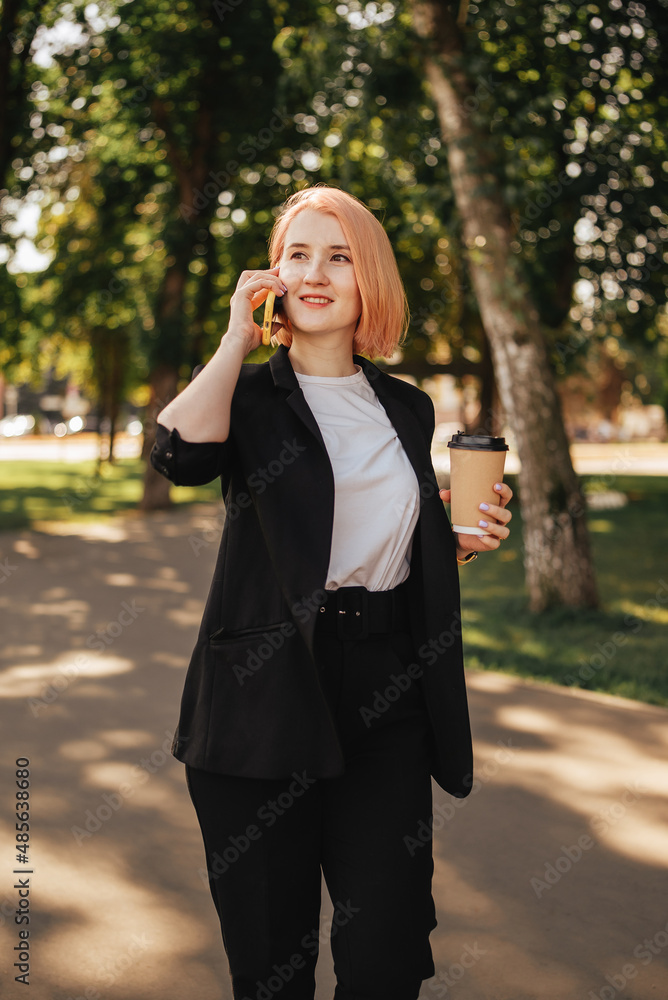 Young woman talking by mobile phone device outdoors on a summer day with eco paper made cup of coffe Young woman talking by mobile phone device outdoors on a summer day with eco paper made cup of coffe
