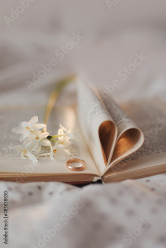 Wedding golden ring and open book with folded sheets in heart shape. Wedding concept, Valentines Day