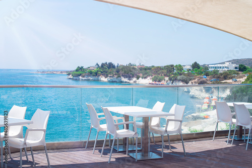 A cafe restaurant on the shores of the Mediterranean Sea. Tables on the terrace in the rays of the sun.
