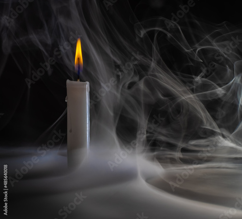 burning candle with mystical smoke. candle flame on a dark background.