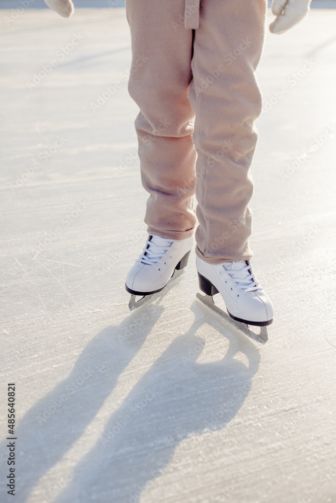 Funny little blonde girl of 7 years old in casual clothes posing on a skating rink in skates. The concept of a child's lifestyle. Layout of the copy space. Funny little blonde girl of 7 years old in casual clothes posing on a skating rink in skates. The concept of a child's lifestyle. Layout of the copy space.