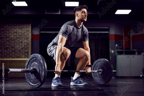 Fit sportsman doing deadlift at the gym and practicing functional training. photo