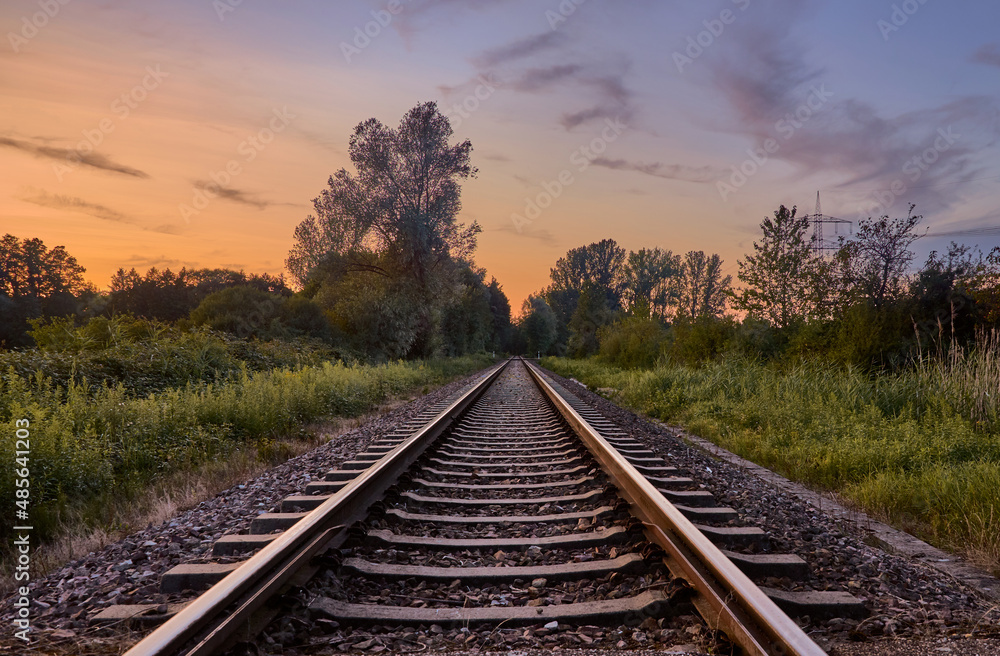 Empty train track at sunset in countryside Empty train track at sunset in countryside