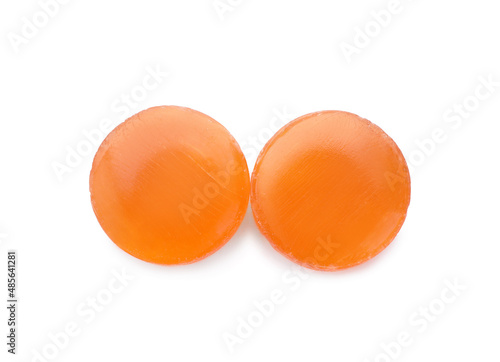 Two orange cough drops on white background, top view