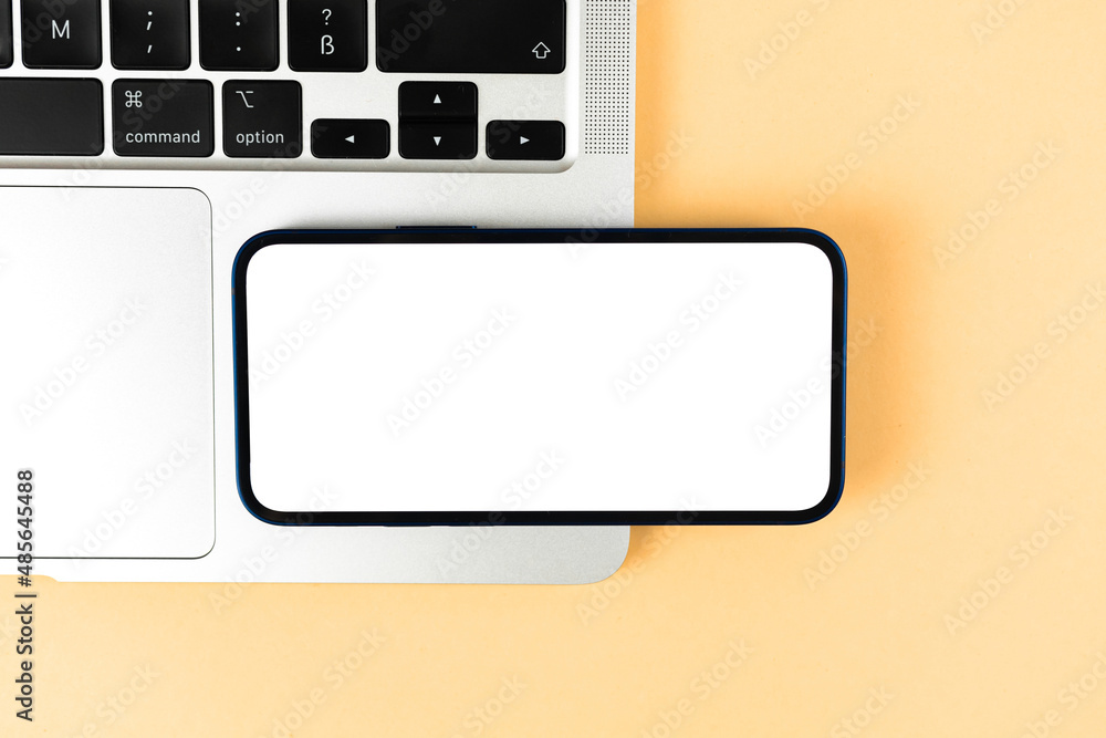 Flat lay smartphone horizontally mockup, office desktop with laptop, bright beige background. Top view, copy space photo Flat lay smartphone horizontally mockup, office desktop with laptop, bright beige background. Top view, copy space photo