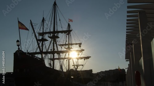 Silhouette of Spanish galleon docked in port at sunset photo