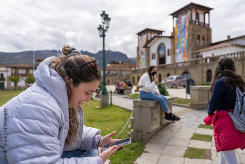 Young woman using the mobile while sitting on an ur¡ban park © Guillermo Spelucin