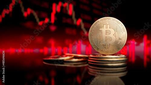 Bitcoin token standing in front of a blurred red price chart. photo