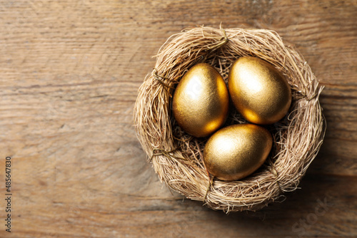 Wallpaper Mural Nest with golden eggs on wooden table, top view. Space for text Torontodigital.ca