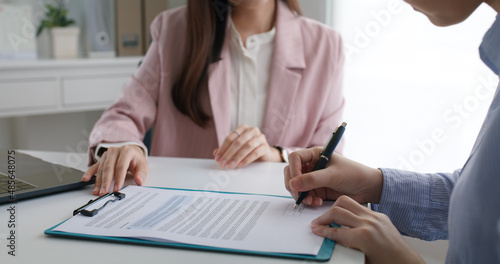 Close-up hand asia people woman fill rent loan form write legal debt letter at lawyer home office. Happy female life buy or sell new house deal from real estate sale agent. Tax advice talk and smile.