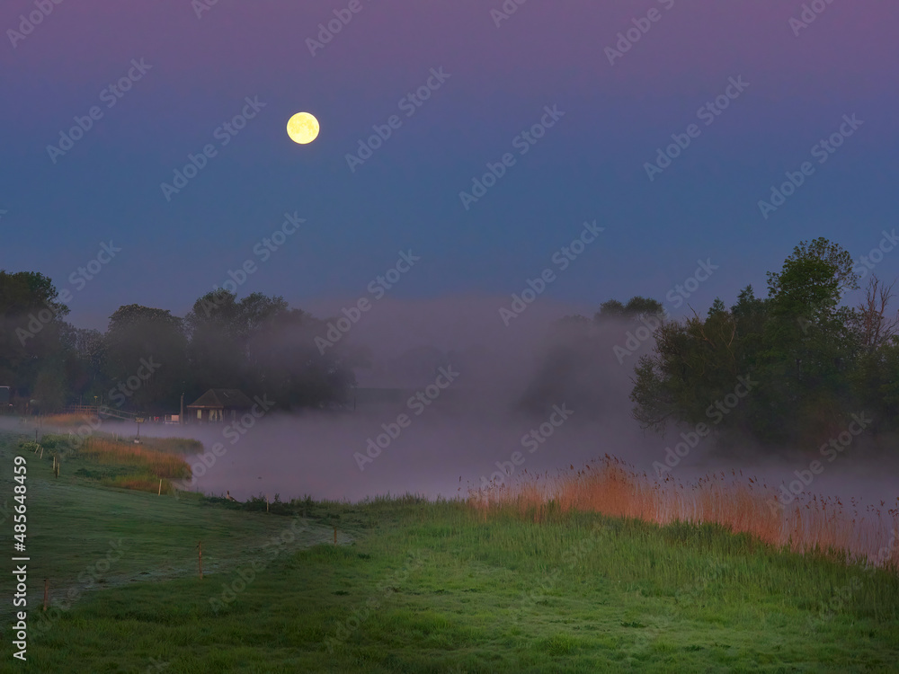 moonlight shines on the landscape just before sunrise. moonlight shines on the landscape just before sunrise.