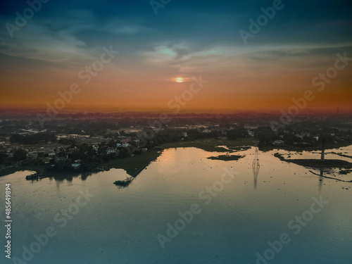 Aerial shot view from the drone on the road river and city of Dhaka near Rangoon river at sunset colors. Shooting from the air. The view is unbelievably beautiful. Aerial Drone 4K