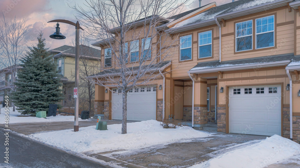 Αυτοκόλλητο Panorama Puffy clouds at sunset Townhouses exterior with attached garage and a d