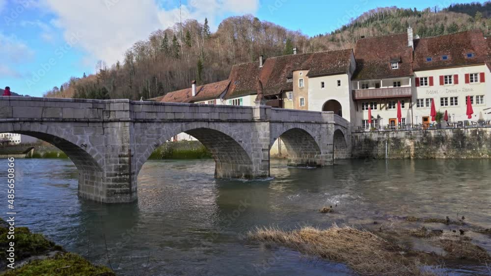 Medieval town Saint-Ursanne, Canton Jura, with beautiful facades of historic houses and stone bridge over river Doubs. Movie shot February 7th, 2022, Saint-Ursanne, Switzerland. Medieval town Saint-Ursanne, Canton Jura, with beautiful facades of historic houses and stone bridge over river Doubs. Movie shot February 7th, 2022, Saint-Ursanne, Switzerland.