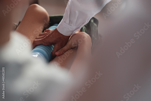 Billede på lærred Hands of doctor or parent, volunteer,caregiver helping hold the cylinder for urinating for child with a disability, Equipment to facilitate hygiene in the excretion of disabilities person concept