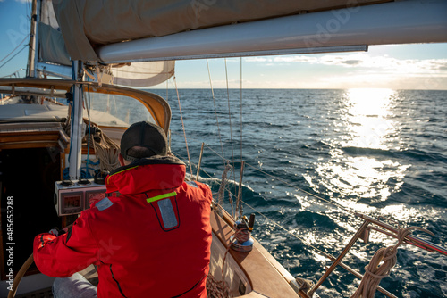 Man steering yacht on the bay of Alicante, Costa Blanca, Spain