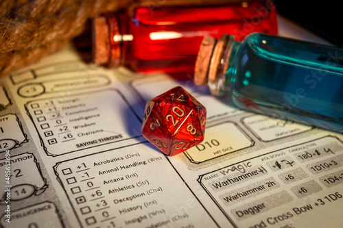 Close-up of a red d20  on a character sheet photo