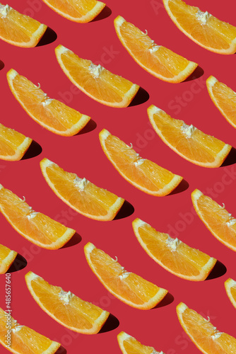 Summer composition made from oranges, on dark red background. Creative Pattern made of slices of orange. 