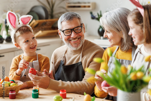 Photography Happy little children creating beautiful painted eggs for Easter with loving sen