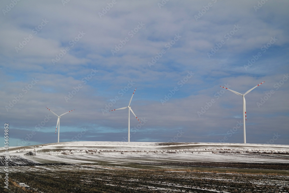 Turbina wiatrowe na polach zimą. - obrazy, fototapety, plakaty 