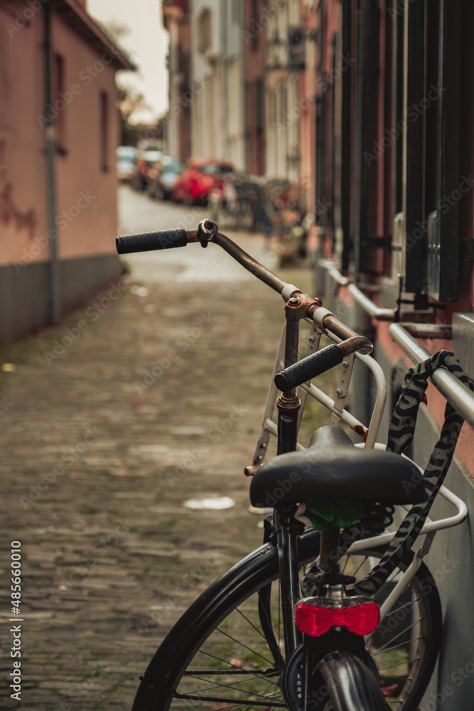 An old rusty bike locked in the middle of the city