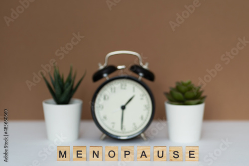 Concept. The inscription from the letters menopause. Symptoms of Menopause Harmonious changes in women older than 40 years.