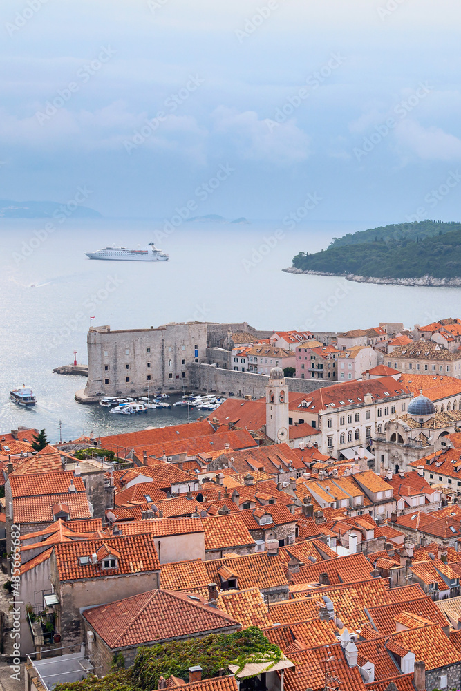top view of the ancient Croatian city of Dubrovnik, a quiet bay with boats and a cloudy sky
