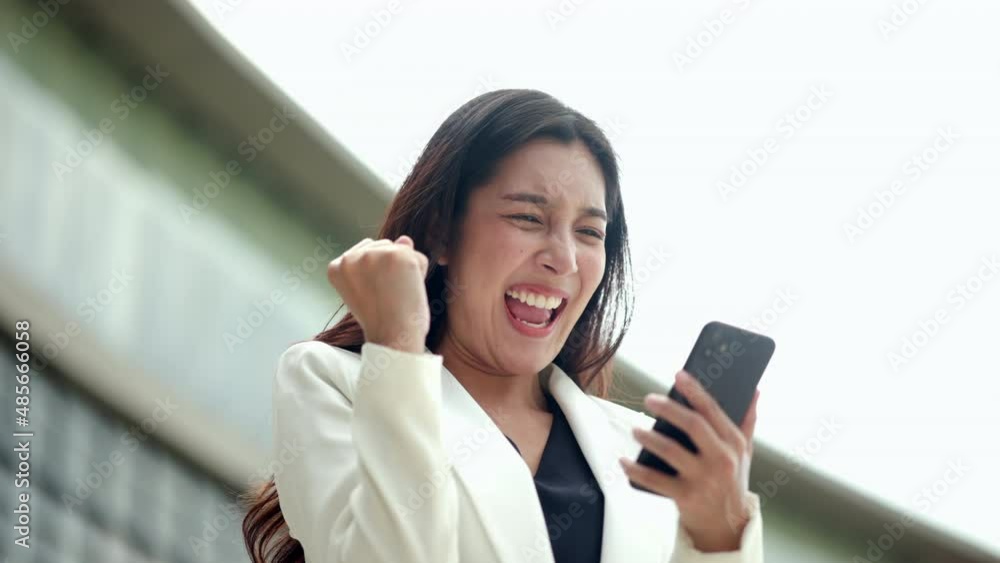 Wow. Happy business woman surprise and excited when looking at mobile phone in the buildings at downtown. Successful female achieve their goals business. Smartphone concept. Wow. Happy business woman surprise and excited when looking at mobile phone in the buildings at downtown. Successful female achieve their goals business. Smartphone concept.