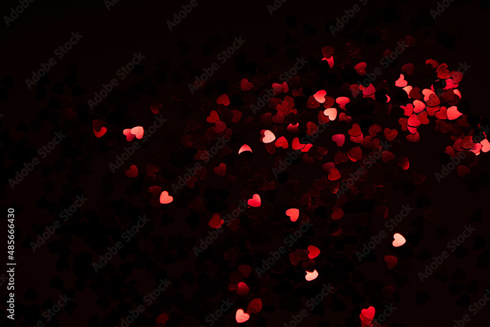 red festive confetti in the shape of a heart on a black background red festive confetti in the shape of a heart on a black background