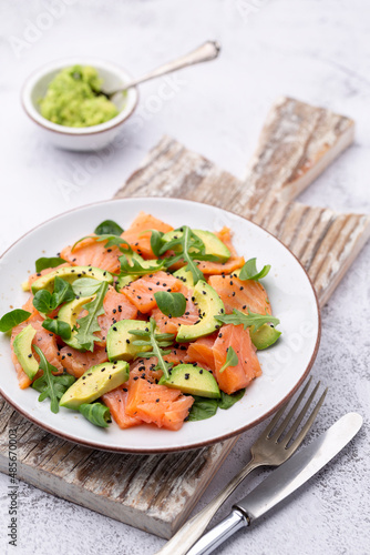 Fresh salmon salad with avocado,  for keto and low carb diet. Rusty background, top view, copy space.