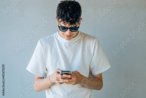 young teenager with sunglasses and mobile phone with space