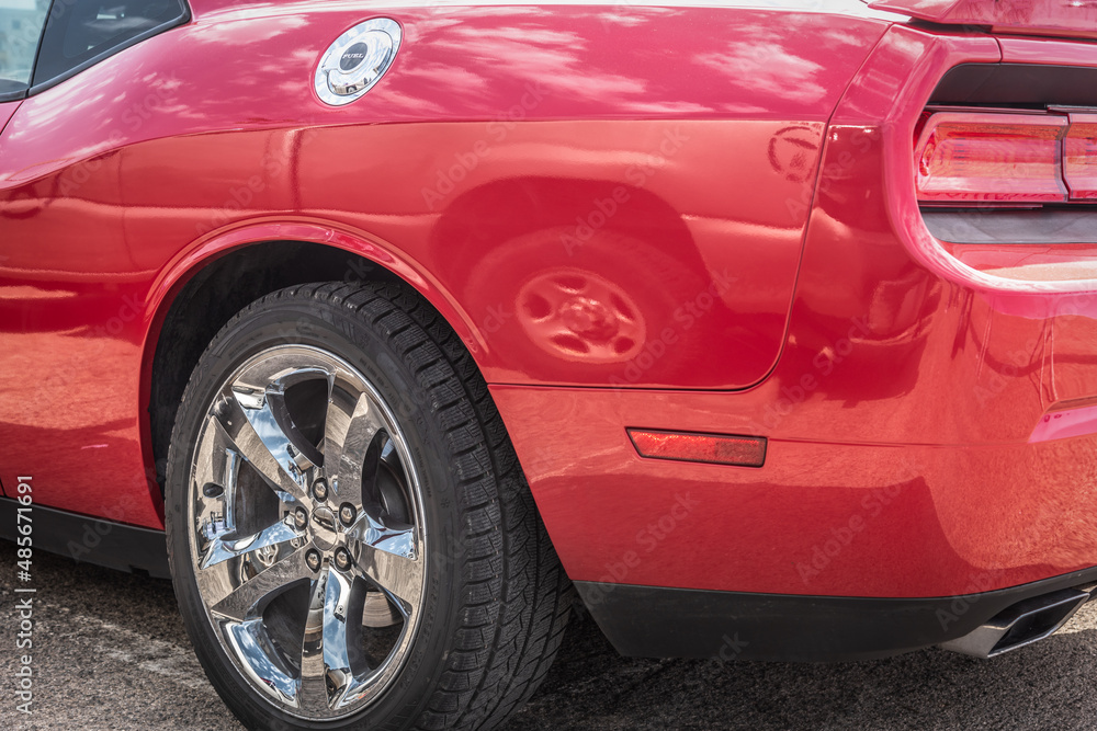 Red muscle car's chrome wheel close up