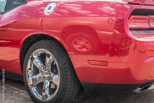 Red muscle car's chrome wheel close up © Gabriele Maltinti