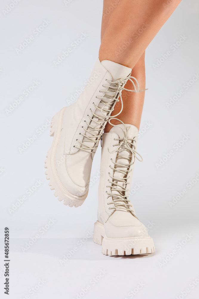 Woman's legs in a collection of fashionable leather white shoes on a white background, spring collection of women's shoes Woman's legs in a collection of fashionable leather white shoes on a white background, spring collection of women's shoes
