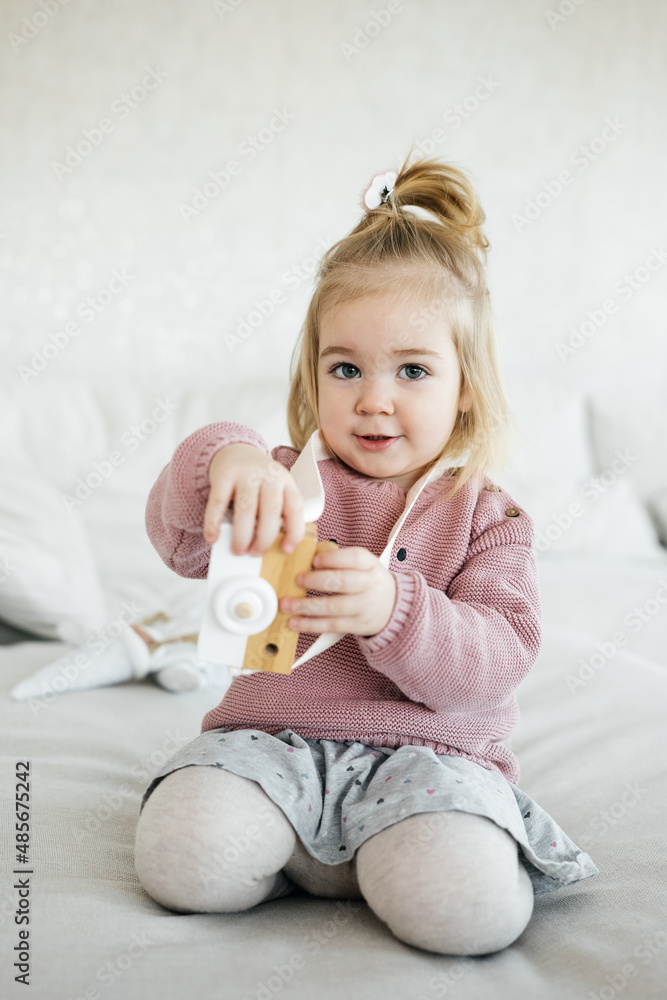 Small adorable girl holding wooden toy camera Small adorable girl holding wooden toy camera