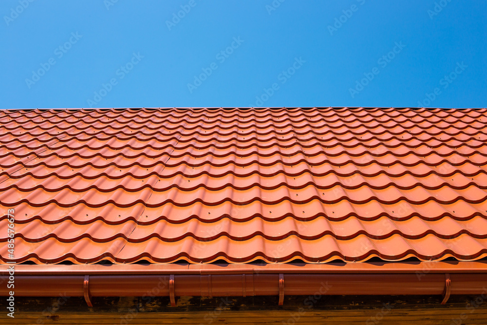 Metal tile roof and downpipe gutter. Construction and repair of the house