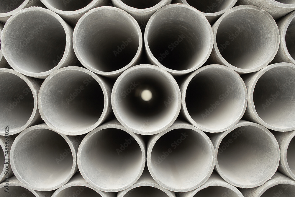 Pipes at the hardware store used for the construction. Close up concrete, cement pipes stacking, pattern background. Asbestos pipes for irrigation. Pipes at the hardware store used for the construction. Close up concrete, cement pipes stacking, pattern background. Asbestos pipes for irrigation.