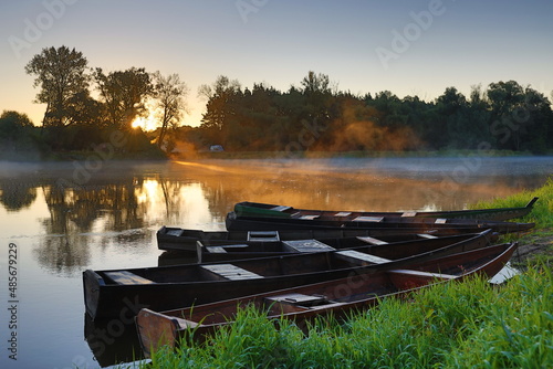 Wschód słońca nad Bugiem z łódkami photo