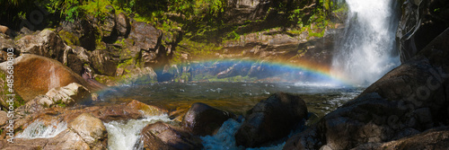 Panoramic Photo of Rainbow at Wainui Falls, a Waterfall in Golden Bay Region, South Island, New Zealand photo